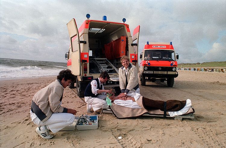 Wasserwacht auf der Insel Sylt: Ein aus dem Wasser Geretteter wird am Strand reanimiert, 1980er Jahre