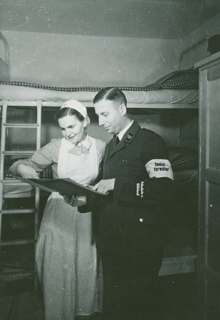 Eine DRK-Helferin und der Bunkerverwalter des Luftschutzbunkers in Berlin-Tempelhof prüfen die Liste mit den Namen der Anwesenden, 1941 (Stenner / DRK)